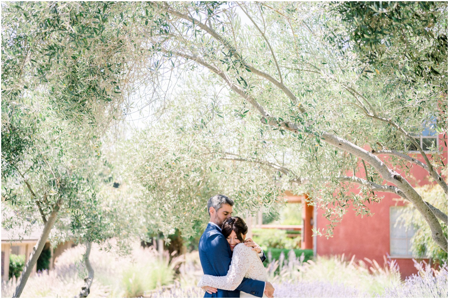 Bride and groom hugging surrounded by trees